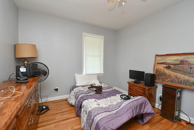 bedroom featuring ceiling fan, baseboards, and wood finished floors