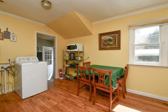 dining area with visible vents, wood finished floors, crown molding, baseboards, and washer / dryer