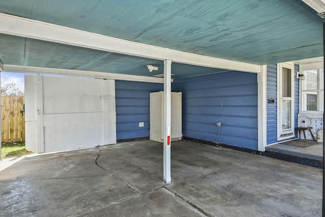 garage with a carport and fence