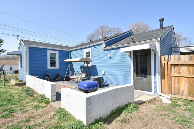 back of house with central AC unit, fence, and a patio