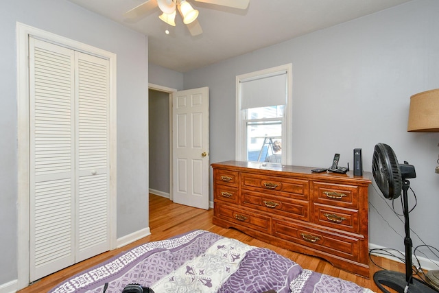 bedroom featuring a closet, baseboards, a ceiling fan, and light wood finished floors