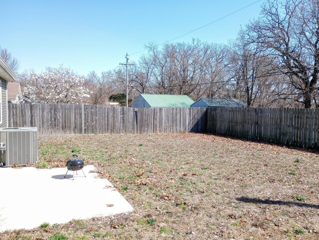 view of yard with cooling unit, a fenced backyard, and a patio