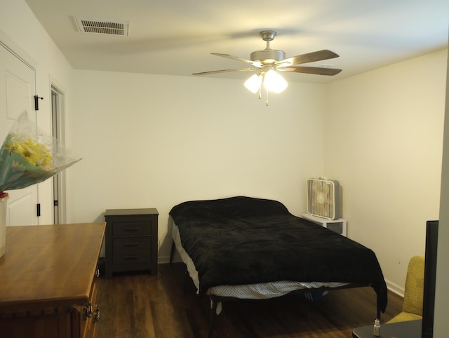 bedroom featuring a ceiling fan, wood finished floors, and visible vents