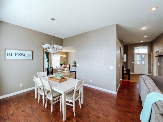 dining space with plenty of natural light, wood finished floors, baseboards, and a chandelier