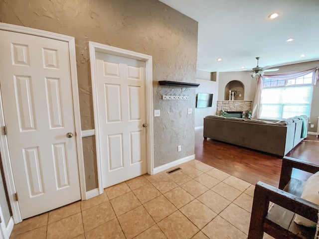 interior space featuring visible vents, ceiling fan, recessed lighting, a fireplace, and light tile patterned flooring