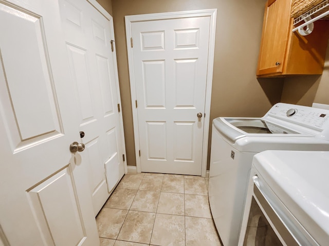 clothes washing area featuring light tile patterned flooring, cabinet space, and independent washer and dryer