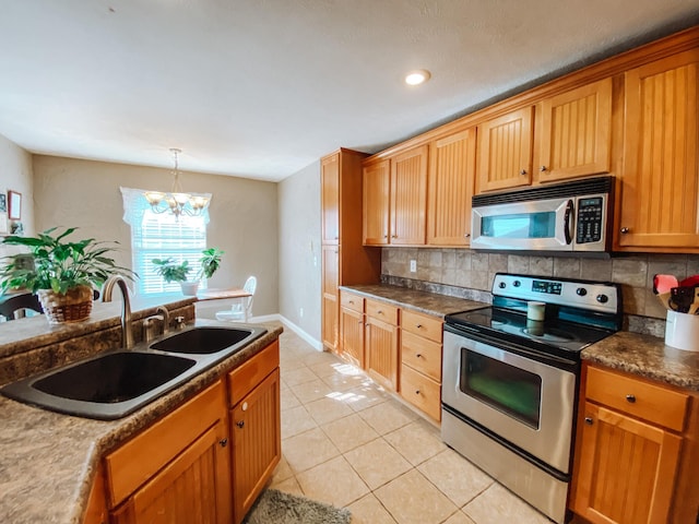 kitchen featuring a sink, decorative backsplash, appliances with stainless steel finishes, and light tile patterned flooring