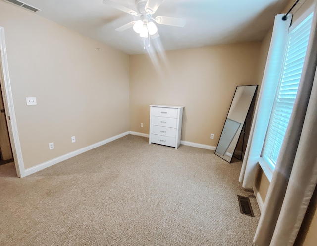 unfurnished bedroom with a ceiling fan, baseboards, visible vents, and light carpet