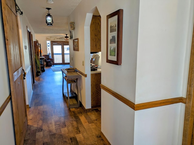 hallway featuring baseboards and dark wood-style flooring