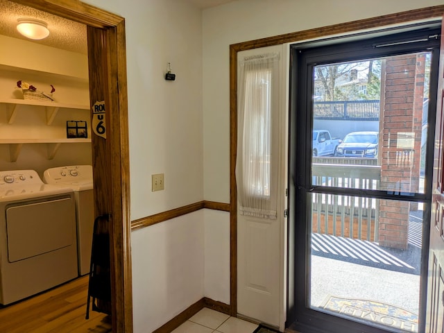 foyer entrance featuring washer and dryer, baseboards, and a textured ceiling