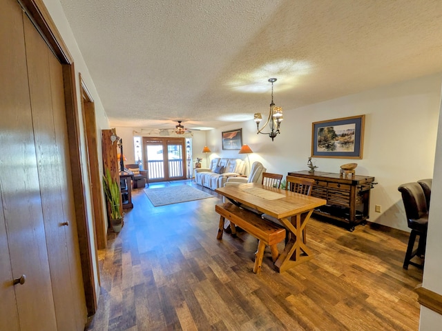 dining space with baseboards, a textured ceiling, wood finished floors, and a ceiling fan