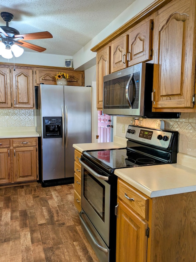 kitchen with light countertops, dark wood-style floors, a ceiling fan, and appliances with stainless steel finishes