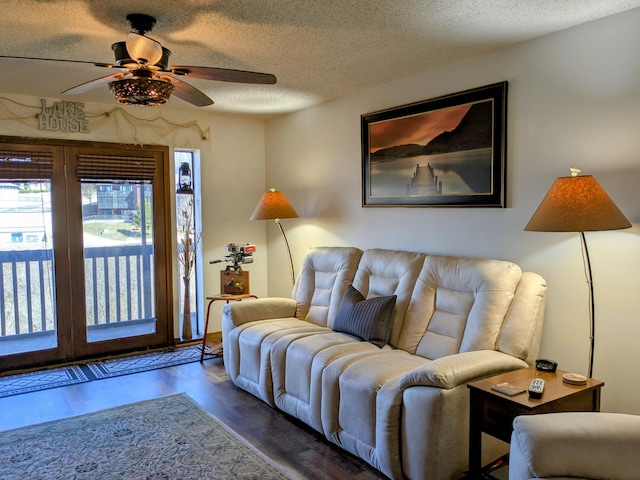 living area with a textured ceiling, ceiling fan, and wood finished floors