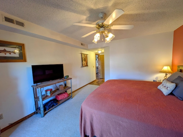 carpeted bedroom with baseboards, visible vents, a textured ceiling, and a ceiling fan