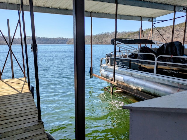 view of dock with boat lift and a water view