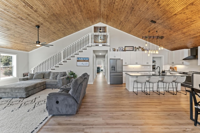 living room with stairway, wood ceiling, light wood-style floors, and high vaulted ceiling