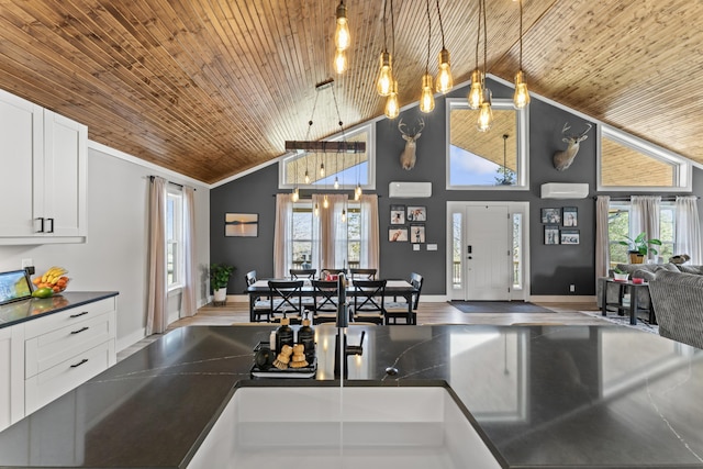 kitchen with plenty of natural light, dark countertops, wood ceiling, and white cabinetry