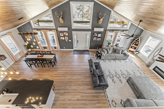 living area featuring wooden ceiling, wood finished floors, baseboards, and high vaulted ceiling