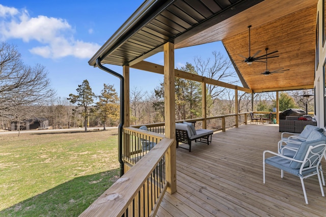 wooden deck with a lawn and a ceiling fan