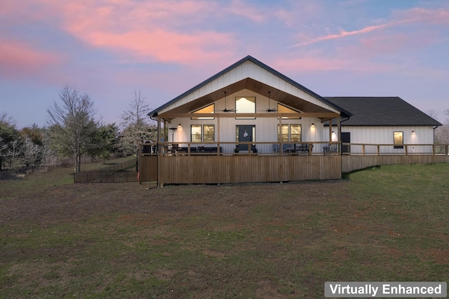 back of property featuring a lawn and fence