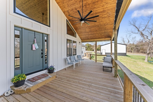 wooden terrace featuring a yard and ceiling fan