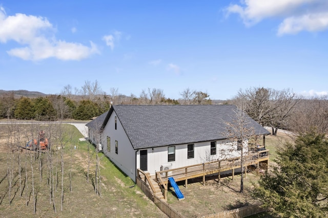 back of house featuring a shingled roof