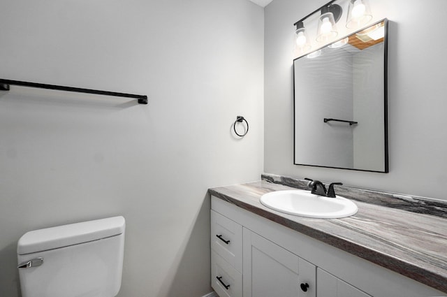 half bathroom with vanity and toilet