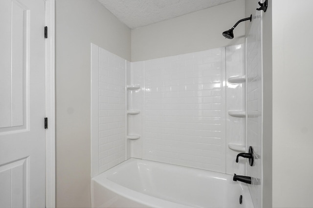 full bathroom with washtub / shower combination and a textured ceiling