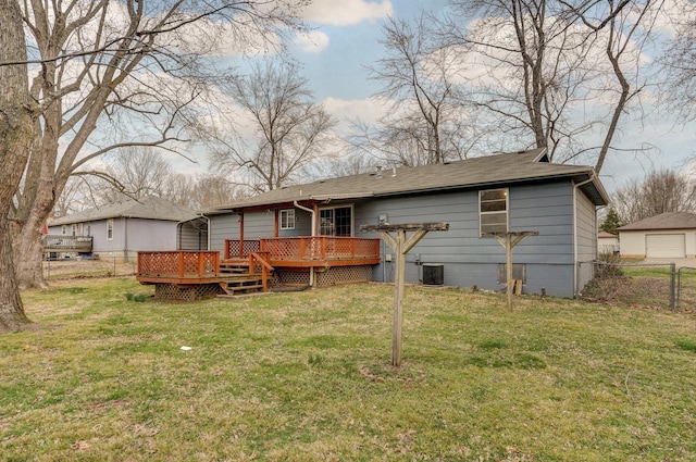 rear view of property featuring a lawn, central AC unit, a deck, and fence