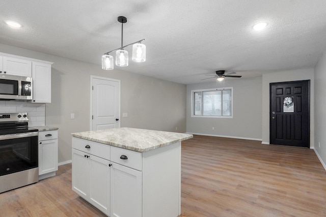 kitchen featuring tasteful backsplash, ceiling fan, light wood-style flooring, stainless steel appliances, and white cabinetry