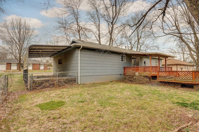 back of property featuring a deck, fence, and a lawn