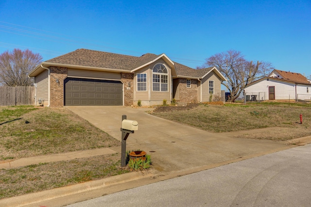 ranch-style home featuring brick siding, a front lawn, fence, concrete driveway, and a garage