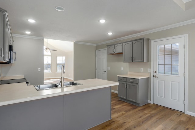 kitchen featuring crown molding, gray cabinets, a peninsula, range with electric stovetop, and a sink