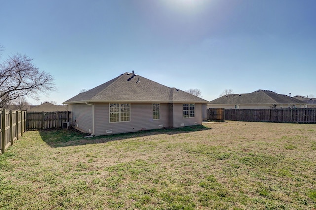 rear view of property with a lawn and a fenced backyard