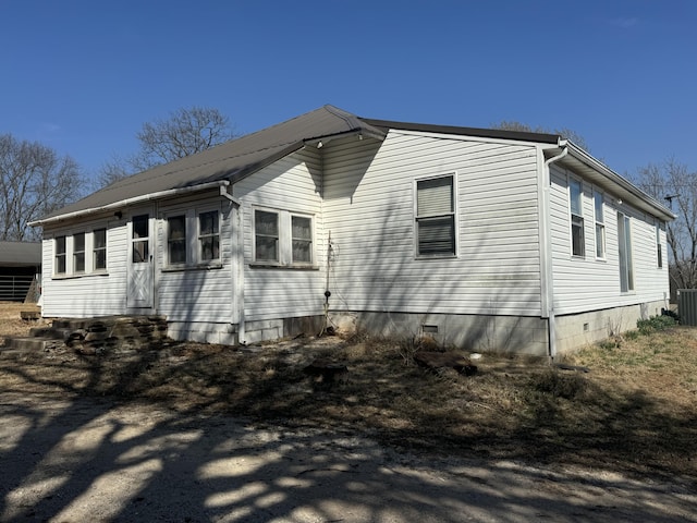 view of home's exterior with crawl space, cooling unit, and metal roof