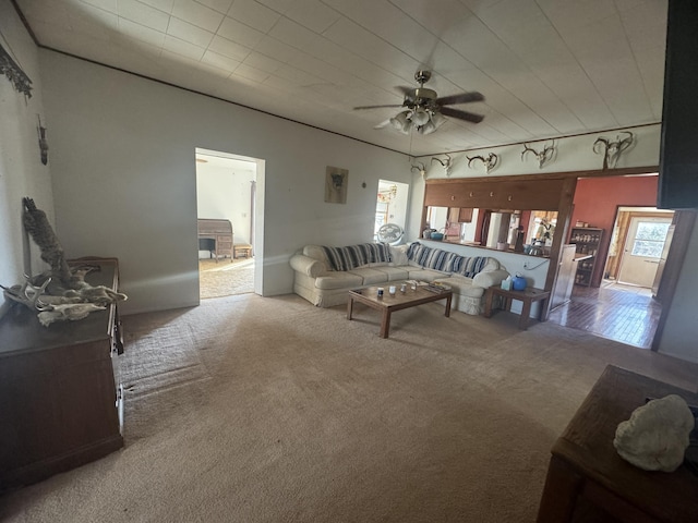 carpeted living area featuring a ceiling fan