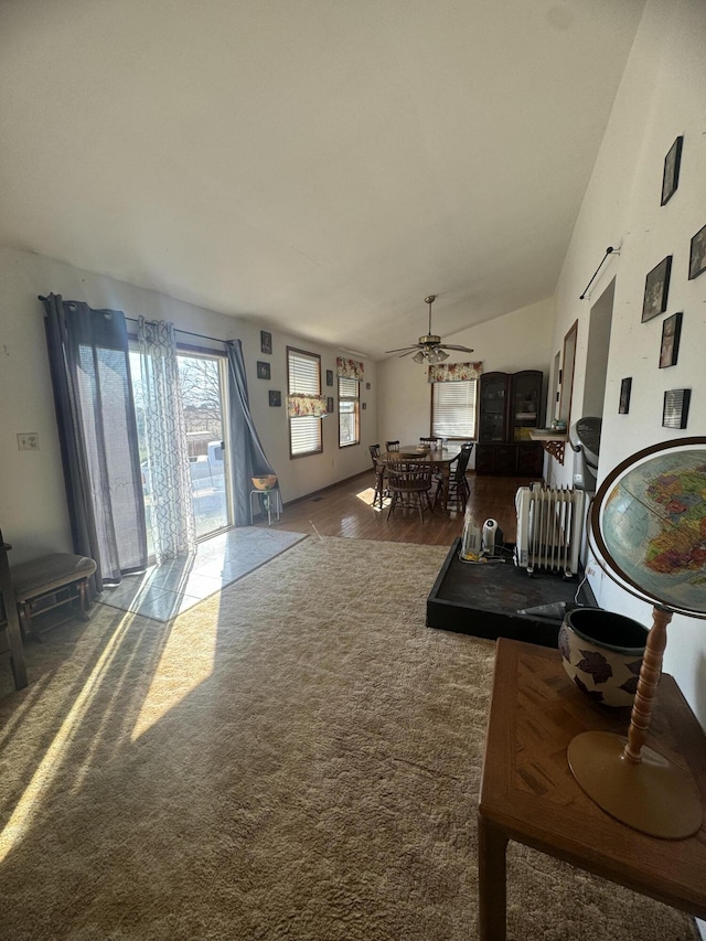 living room featuring a ceiling fan and vaulted ceiling