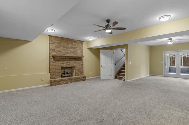 unfurnished living room featuring stairway, carpet, and ceiling fan