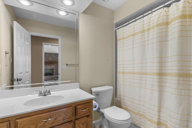 full bath with curtained shower, toilet, and vanity