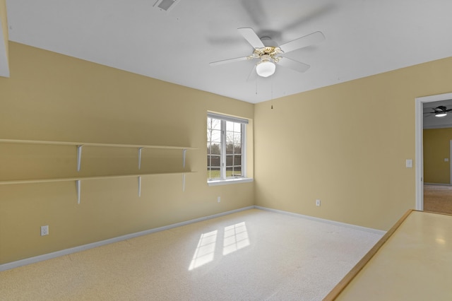 spare room with carpet flooring, baseboards, and ceiling fan