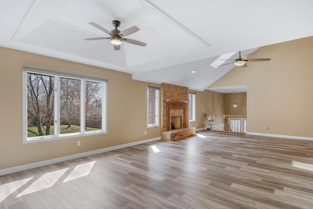 unfurnished living room with lofted ceiling, baseboards, light wood-style floors, and a ceiling fan