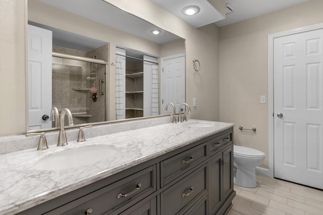 bathroom with a shower stall, toilet, double vanity, and a sink