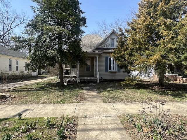 view of front facade featuring covered porch and a front yard