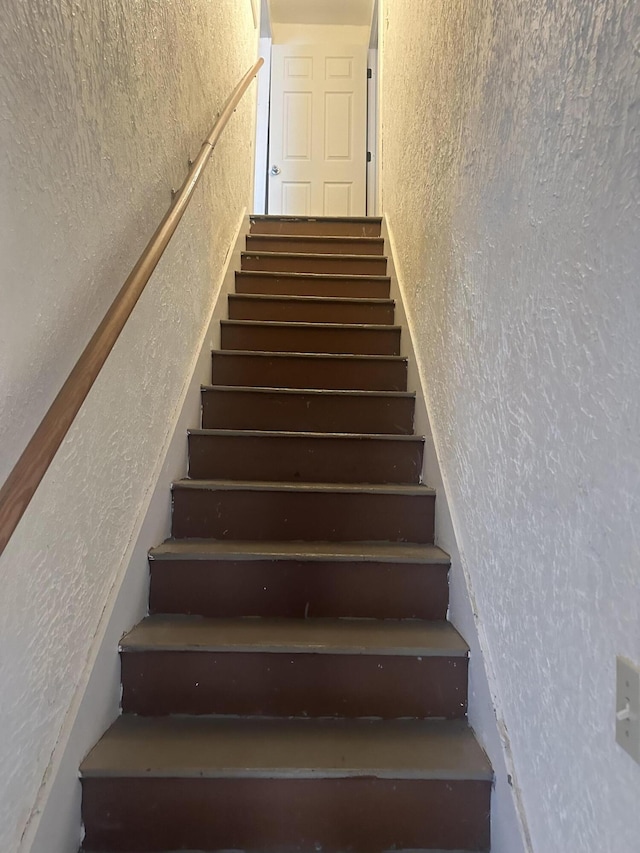 staircase featuring a textured wall