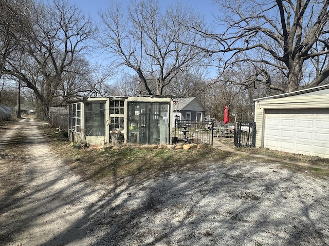 view of outbuilding featuring an outdoor structure, fence, and a garage