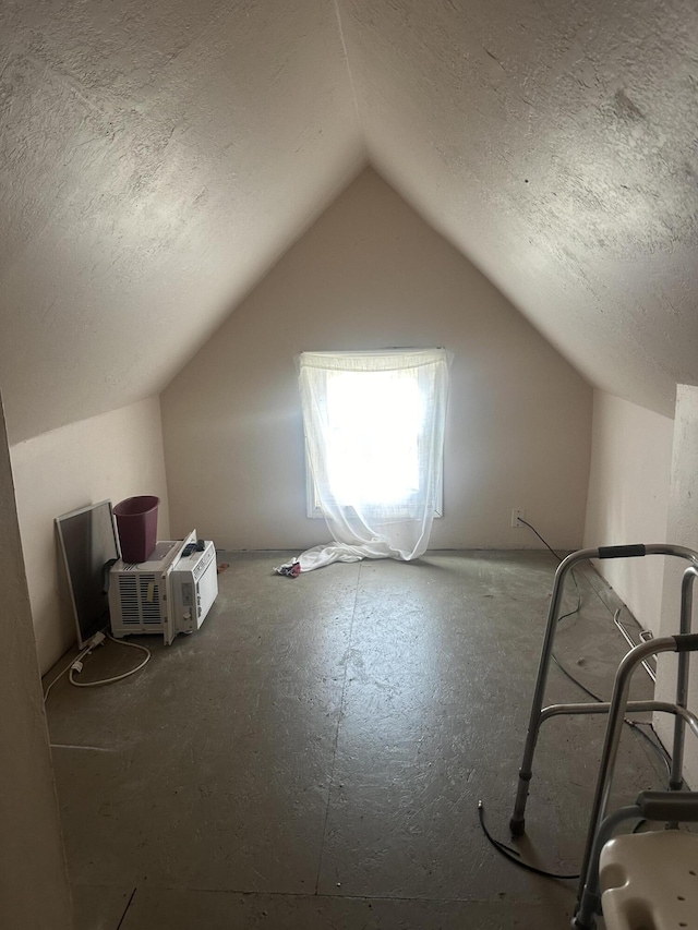 additional living space featuring lofted ceiling and a textured ceiling