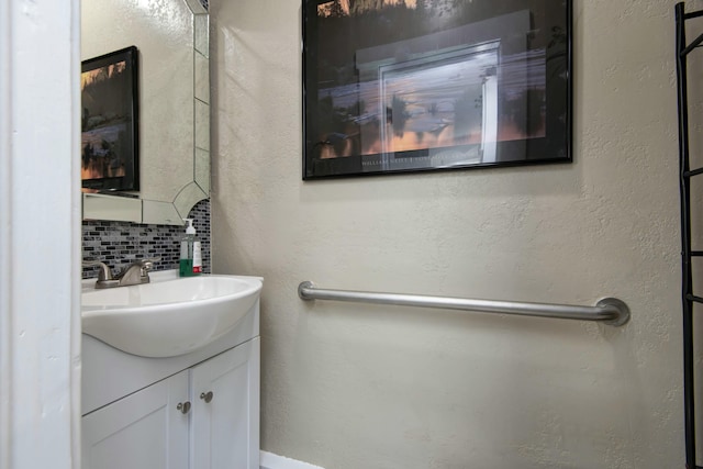 bathroom with tasteful backsplash, vanity, and a textured wall