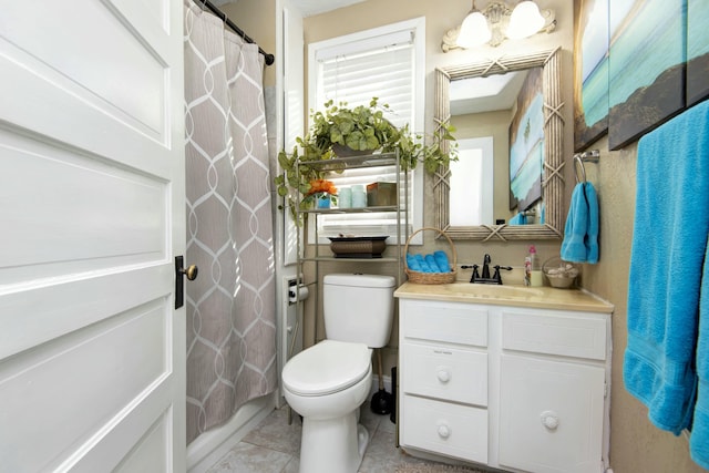 bathroom featuring toilet, vanity, and tile patterned flooring