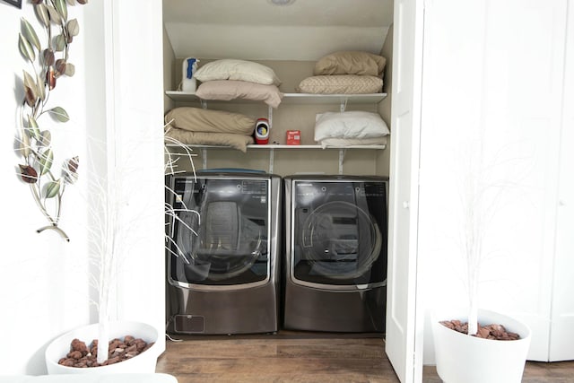 clothes washing area with laundry area, washer and dryer, and wood finished floors