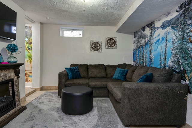 living room featuring tile patterned flooring, a fireplace, baseboards, and a textured ceiling